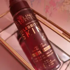Butelka mgiełki Eveline Celebrity Skin w złotym stojaku.
