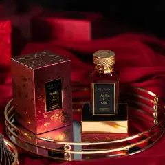 Eleganckie perfumy Sorvella Vanilla & Oud w czerwonym, złotym opakowaniu, otoczone luksusowym materiałem. Trwale perfumy, które podkreślą Twój styl.
