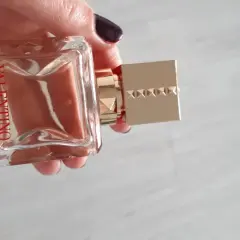 Elegancki flakon Valentino Voce Viva 100ml w dłoni, z charakterystycznym złotym korkiem ozdobionym ćwiekami.