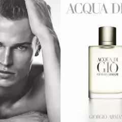 Mężczyzna z ręką we włosach obok flakonu perfum Acqua di Gio Profumo Giorgio Armani.