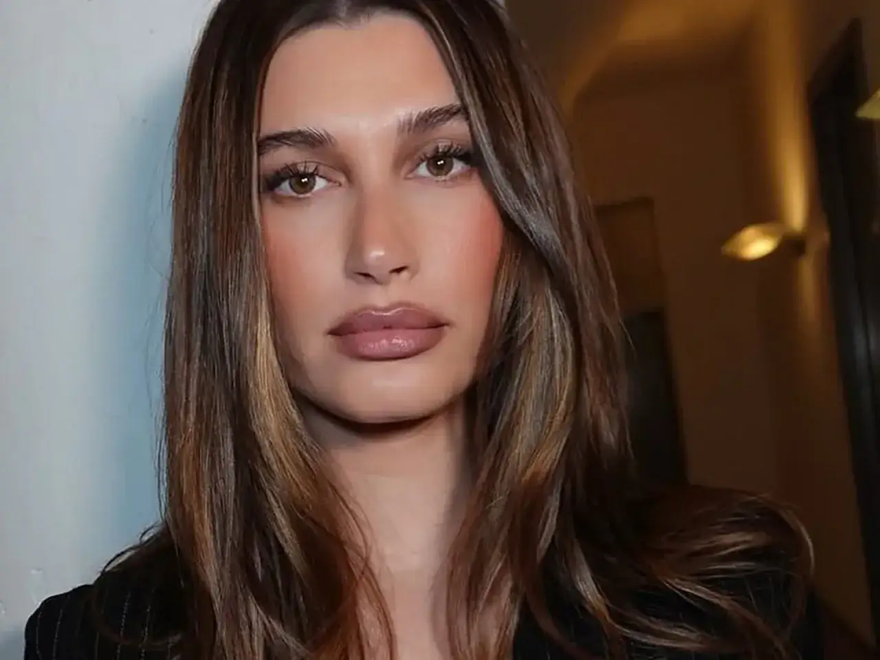 Jaki kolor włosów dla siwiejącej szatynki? Modelka z brązowymi włosami i subtelnymi refleksami, idealna inspiracja.