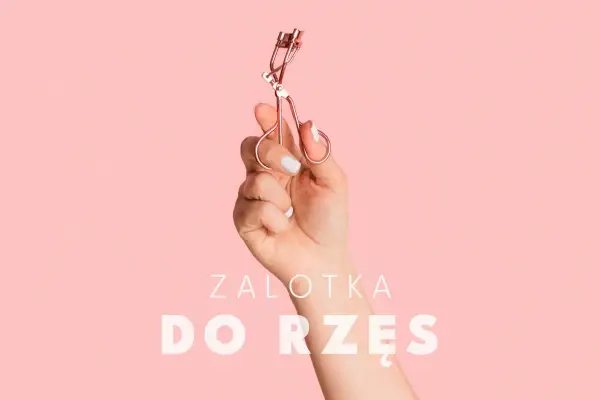 Dłoń trzyma zalotkę do rzęs. Czy zalotka niszczy rzęsy? Dowiedz się, jak jej używać, by ich nie uszkodzić.